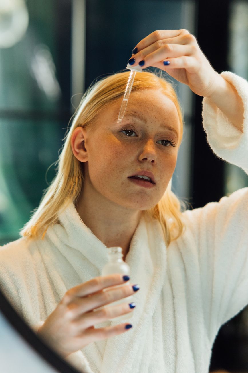 Woman applying LYS serum in soft daylight